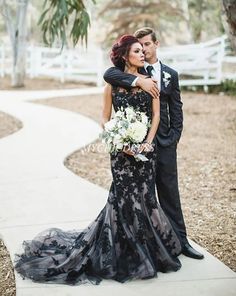 a man and woman in formal wear standing on a path