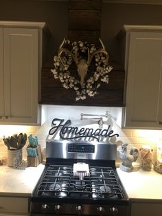 a stove top oven sitting in a kitchen under a deer head mounted on the wall