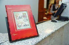 a red book sitting on top of a counter next to a woman in a black shirt