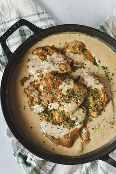 a skillet filled with chicken covered in gravy