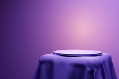 a round table with a purple cloth on it and a white plate sitting on top