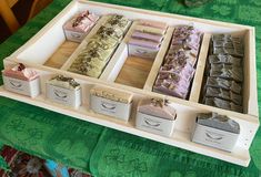 a tray filled with different types of soaps on top of a green table cloth