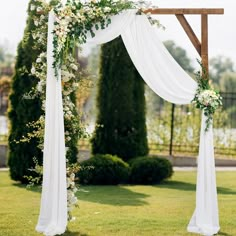 an outdoor wedding ceremony with white draping and greenery