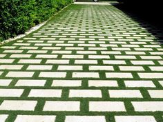 a brick walkway with grass growing on it