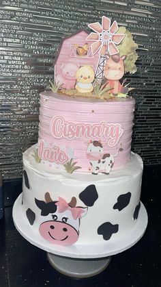 a three tiered cake decorated with farm animals and the words cismay on it