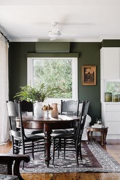 a dining room table with chairs and a rug on the floor in front of it