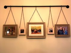 three frames hanging on a wall with chains holding photos and two people in the background