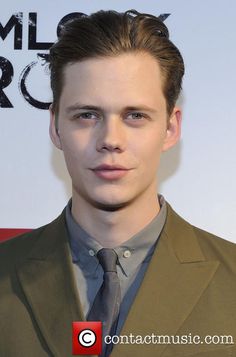 a young man in a suit and tie posing for the camera with his eyes wide open