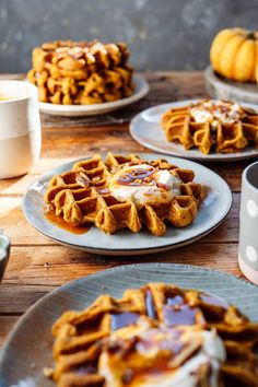 several waffles on plates with caramel syrup drizzled over them