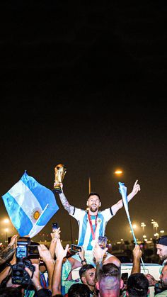 a man holding a trophy in the middle of a crowd