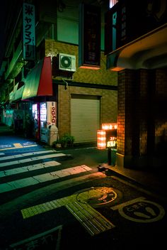 an empty street at night with the lights on and signs lit up in chinese characters