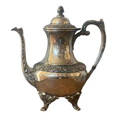 an ornate silver tea pot with gold trimmings