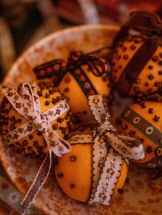 oranges decorated with ribbons and bows in a bowl