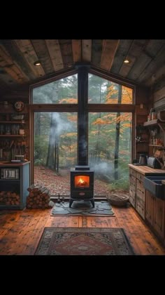 a stove sitting inside of a wooden cabin next to a kitchen and dining room table