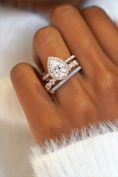 a woman's hand with a diamond ring on top of her finger and two diamonds in the middle