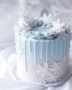 a blue and white frosted cake with snowflakes on it