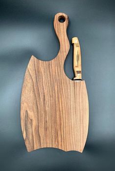 a wooden cutting board with a bottle opener on the side and a corkscrew hanging from it