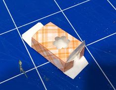 an orange and white box sitting on top of a blue tiled floor next to a knife