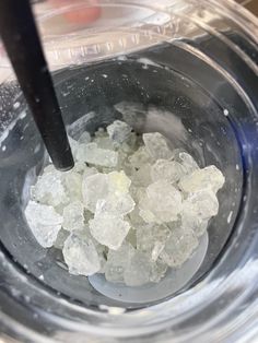 ice cubes in a bowl with a black spoon