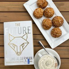 some food is sitting on a plate next to a book and bowl of cream cheese