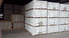 several stacks of white boxes stacked on top of each other in front of a warehouse