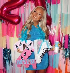 a woman in a blue dress holding up a pair of shoes and a pink sign