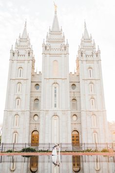 a bride and groom standing in front of the salt lake temple