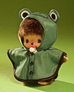 a small doll dressed in a frog costume with a pacifier in its mouth and nose