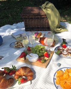 a picnic table with bread, fruit and wine