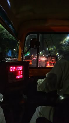 a man sitting in the back seat of a car with an alarm clock on it