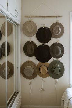 hats are hanging on the wall near a bed