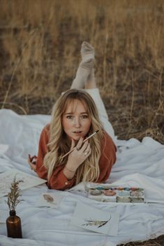 a woman laying on top of a white blanket