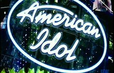 an american idol sign is lit up in front of the stage with neon green lights