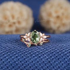 a ring with an oval cut green stone surrounded by small white stones on top of it