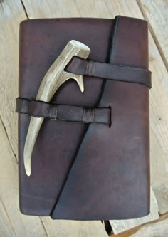 a brown leather journal with a hammer sticking out of it