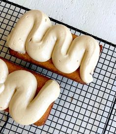 two pieces of bread with white icing on a cooling rack