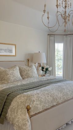 a bedroom with a bed, chandelier and window