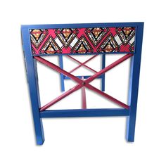 a blue and pink chair with an intricate design on it's backrest, against a white background