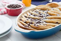 a blue dish filled with chocolate chips and powdered sugar on top of a table