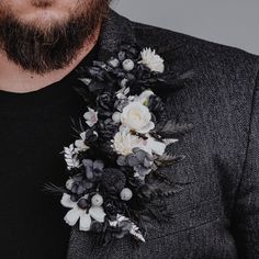 a man with a beard wearing a black and white flower boutonniere