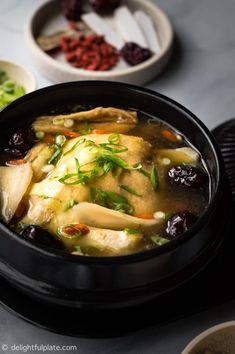 a black bowl filled with soup on top of a table