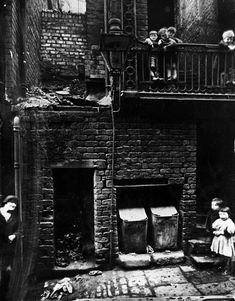 an old black and white photo of children in front of a fire place