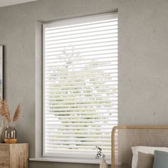 a bedroom with a bed, dresser and window covered in white shutters next to a painting on the wall