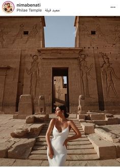 a woman standing in front of an egyptian temple