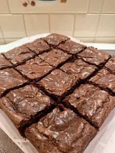 chocolate brownies sitting on top of a white counter next to a blue and white tile wall