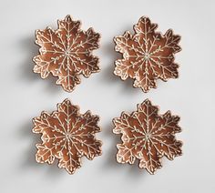 three cookies with frosting on them are arranged in the shape of snowflakes