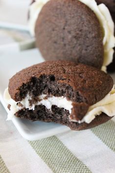 two chocolate cookies with white frosting are on a plate