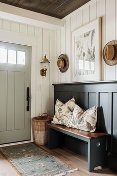 a bench with pillows on top of it in front of a door and some pictures