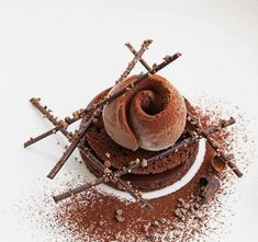 a chocolate dessert is garnished with cinnamon sticks