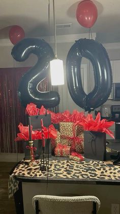 a table with presents and balloons in the shape of the number twenty five on it